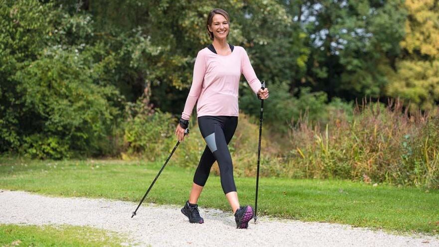 una donna è impegnata a camminare per prevenire il mal di schiena