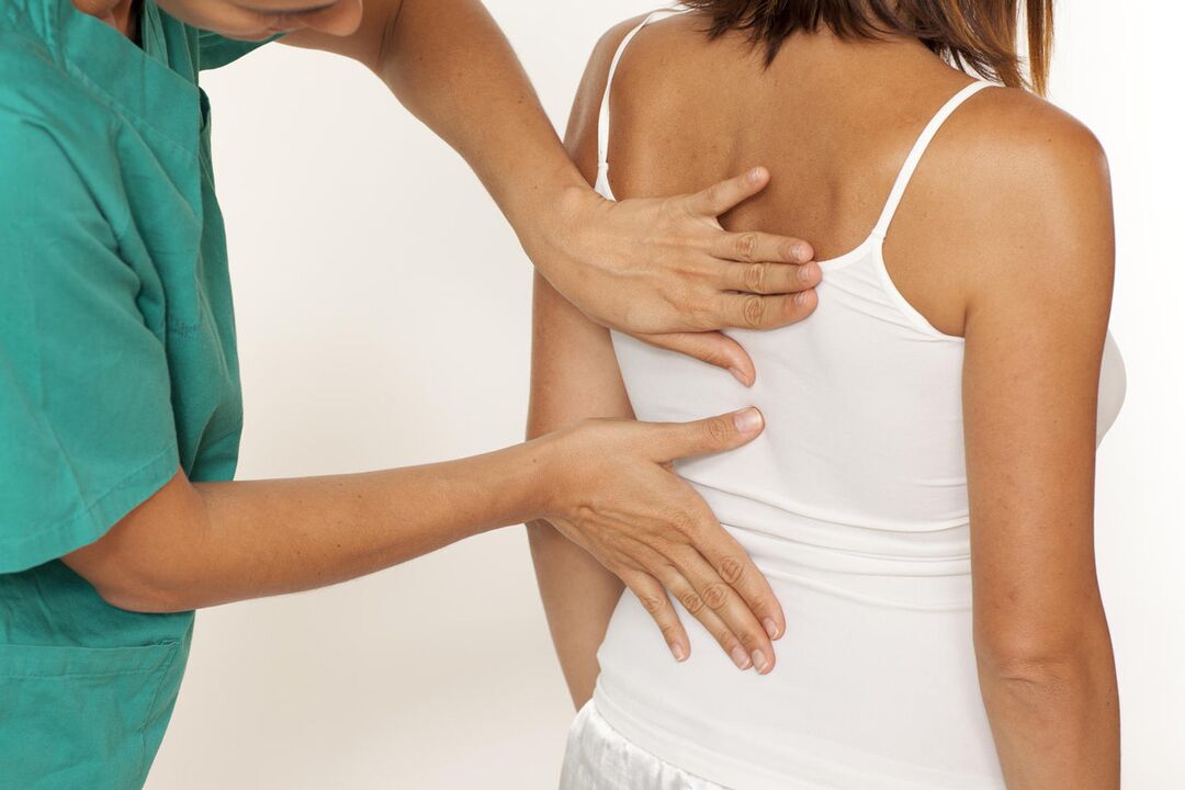 Il medico esamina la schiena per il dolore alle scapole
